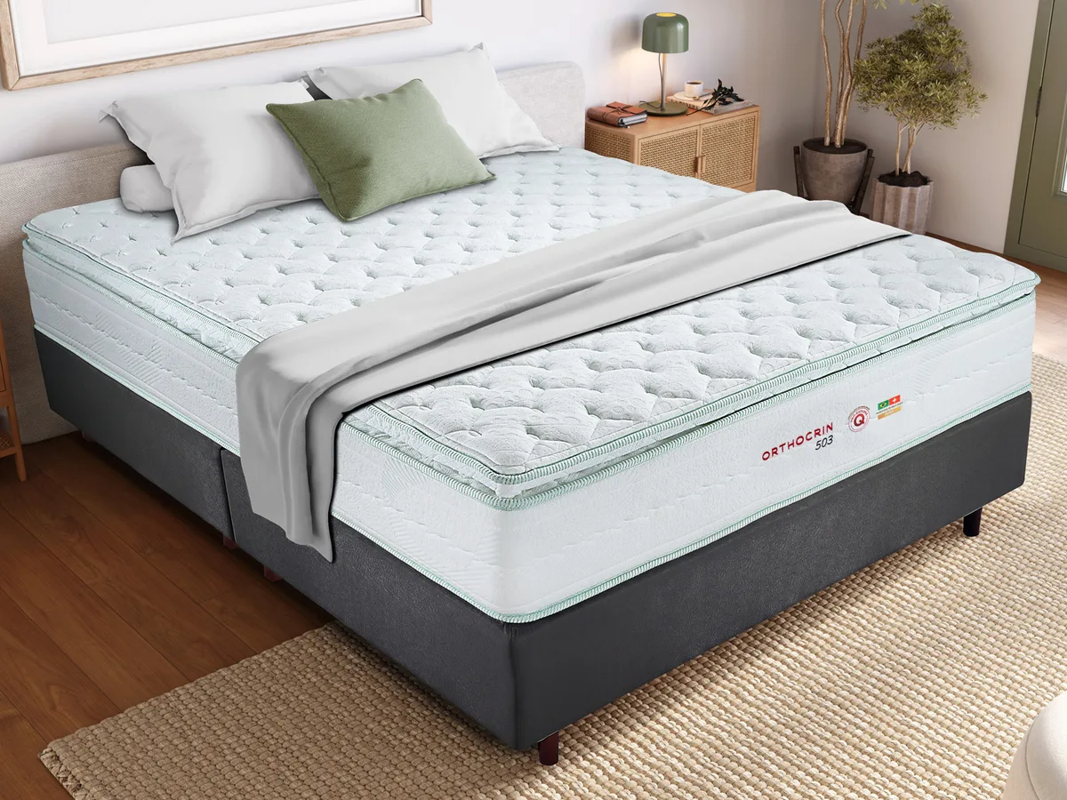 Colchão de molas ensacadas Orthocrin Série 503 sobre cama box escura, em quarto montado